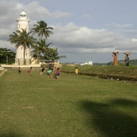 Dječaci igraju kriket, Galle Svjetionik i bedem oko Galle Fort, Galle, Južna provincija, Šri Lanka Poster