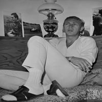 Steve McQueen sjedio je u krevetu koji nosi bijele rukav i bijele hlače u crno-bijeloj ispis fotografija
